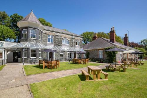 a building with tables and benches in front of it at Broadway Country House in Laugharne