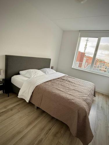 a bedroom with a large bed and a window at The Residence Enschede in Enschede