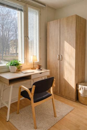 a desk and a chair in a room with a window at Quiet Private Rooms Easy Metro & Airport Access in Vantaa
