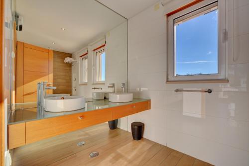 a bathroom with two sinks and a window at Villa Magnolia The Crest 3 quartos e piscina in Almancil
