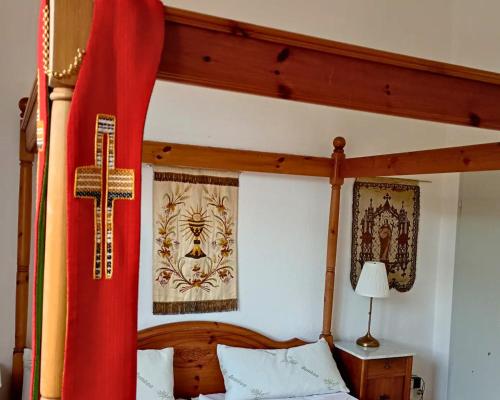 a bedroom with a wooden bed with a cross on it at Das Alte Pastorat in Klotten