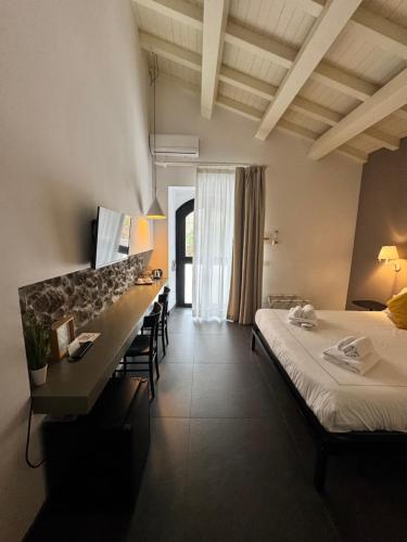a hotel room with two beds and a desk at Talè Restaurant & Suite in Piedimonte Etneo