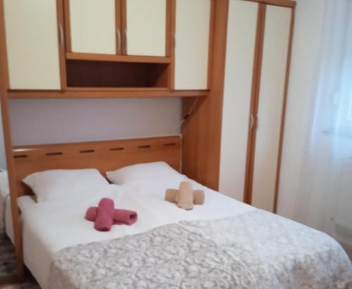two stuffed animals sitting on top of a bed at Apartman Panonia in Slavonski Brod