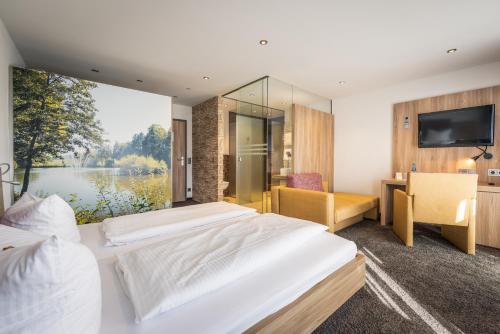 two beds in a room with a large window at Hotel Salinensee in Bad Dürrheim