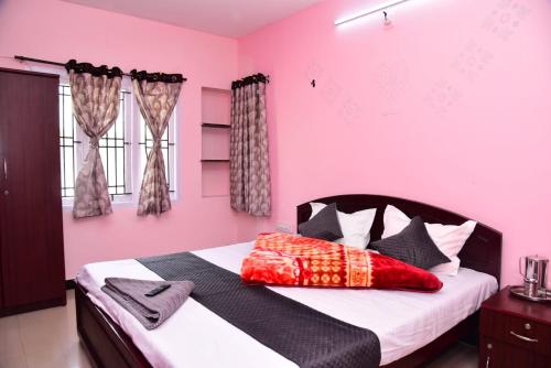 a bedroom with pink walls and a large bed at FFF Cottage in Ooty