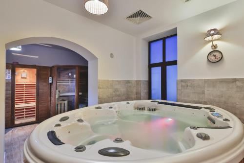 a bath tub in a room with a clock on the wall at Hotel Carol - Vatra Dornei in Vatra Dornei
