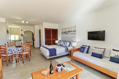 a living room with a bed and a couch at Apartamentos São Rafael - Albufeira, Algarve in Albufeira