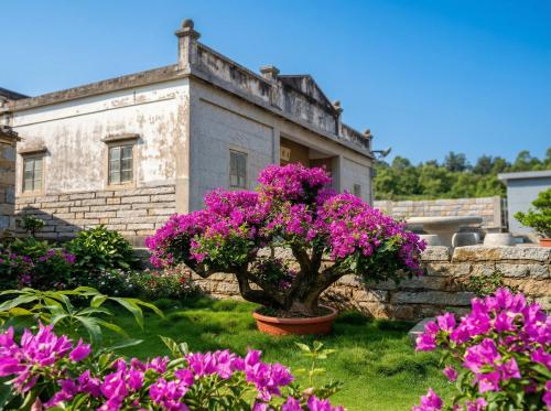 a house with pink flowers in front of it at Zhong Lan Homestay in Chung-lan