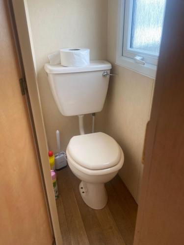 a white toilet in a bathroom with a window at KC Caravans in Ingoldmells