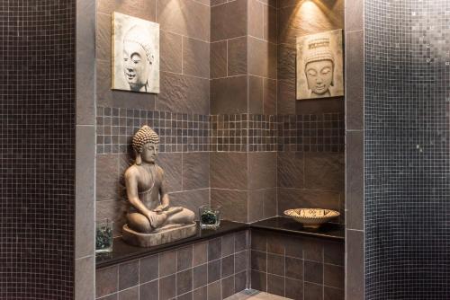 ein Badezimmer mit einer Buddha-Statue an der Wand in der Unterkunft Park Hotel Argento in Levanto