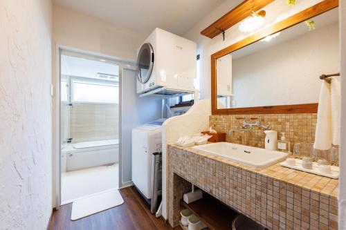 a bathroom with a sink and a mirror at Villa Ferme Yatsugatake in Hokuto
