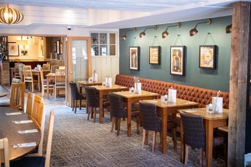 a restaurant with wooden tables and chairs at Abbey Fields By Chef & Brewer Collection in Kenilworth