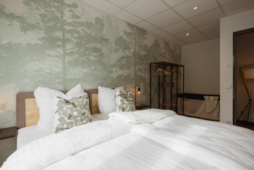 a bedroom with a large bed with a painting on the wall at HYGGE HOMES - Apartment 'silva' in Winsen