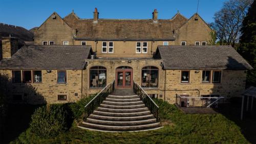 a large brick building with stairs leading to a door at The Old Golf House Sure Hotel Collection by Best Western in Huddersfield