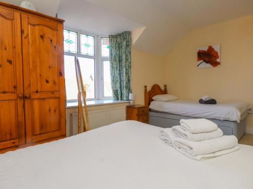 a bedroom with two beds and a window at The Old Stables in Colwyn Bay