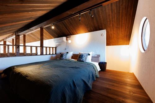 a bedroom with a bed and a wooden ceiling at Villa Ferme Yatsugatake in Hokuto