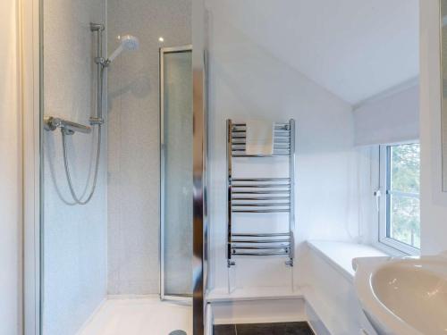 a white bathroom with a shower and a sink at 3 Bed in Conwy oc-85844 in Llanbedr-y-cennin