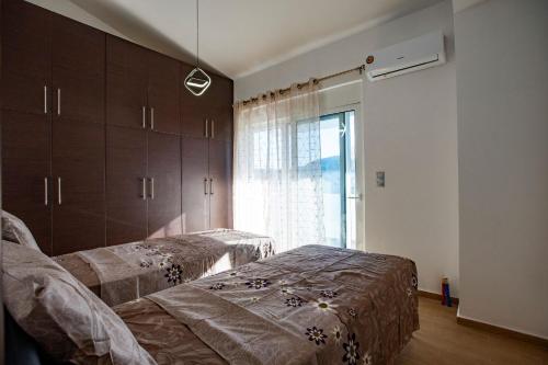 a bedroom with two beds and a window at Natural Quiet Accommodation 3 - Faliraki in Kalithies