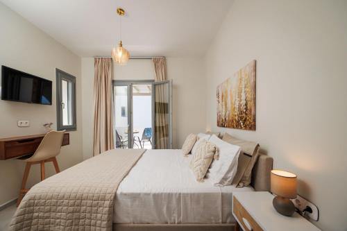 a bedroom with a large bed with a desk and a desk at Etherio Apartments Naxos in Galanádhon