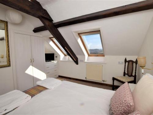 a bedroom with a bed and a window and a chair at 2 Bed in Conwy oc-tycan in Llangelynin