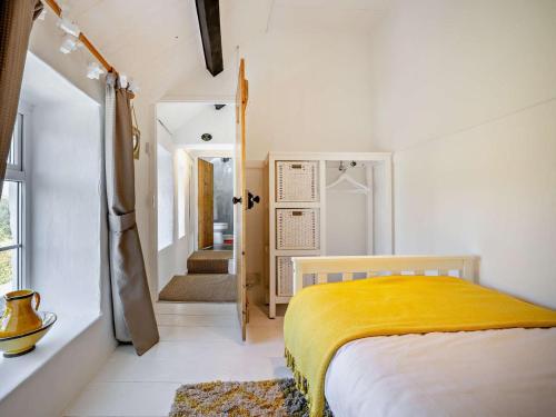 a bedroom with a bed with a yellow blanket at 3 Bed in Pwllheli oc-55571 in Nefyn