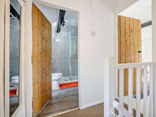 a bathroom with a toilet and a glass door at 3 Bed in Pwllheli oc-55571 in Nefyn
