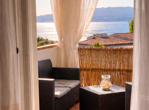 a balcony with a chair and a table with a view of the ocean at La Conia Sea View Retreat in Cannigione