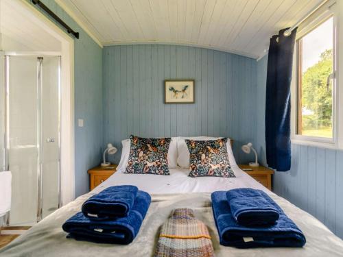 a bedroom with a bed with blue walls at 1 Bed in Kilgetty oc-88421 in Jeffreston