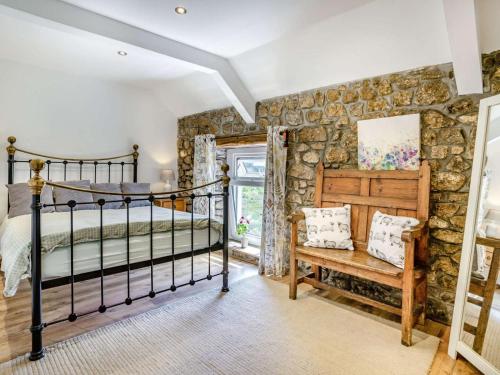 a bedroom with a bed and a stone wall at 2 Bed in Swansea oc-62019 in Reynoldston