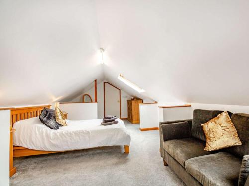 a bedroom with a bed and a couch at 4 Bed in Denbigh oc-62368 in Denbigh