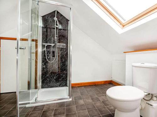 a bathroom with a shower and a toilet at 4 Bed in Denbigh oc-62368 in Denbigh