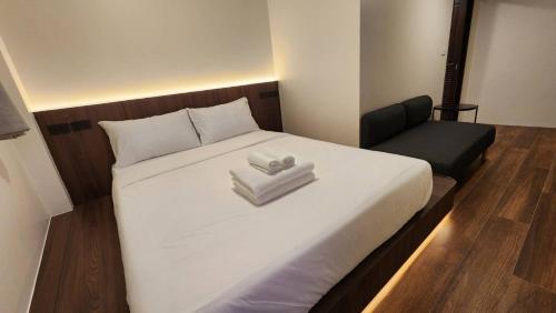 a bedroom with a bed with two folded towels on it at Old City Hall, Contactless Check In in Bangkok