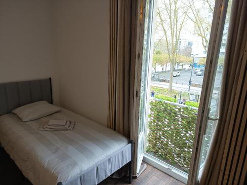 a bedroom with a bed next to a sliding glass door at Hôtel Du Mans in Angers