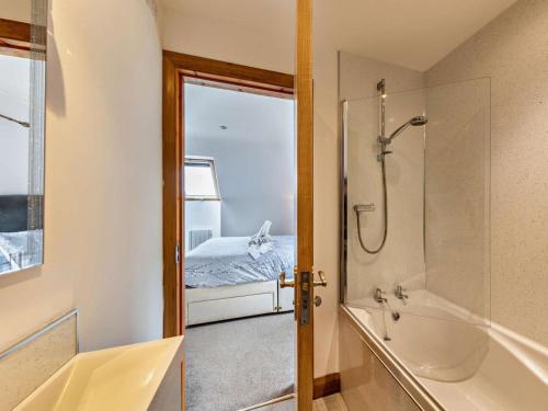 a bathroom with a shower and a tub and a bed at 3 Bed in Arthog oc-77304 in Arthog