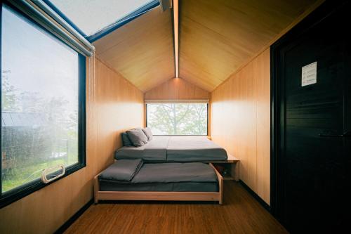 a small bed in a small room with a window at Bobocabin Coban Rondo, Malang in Songgoriti