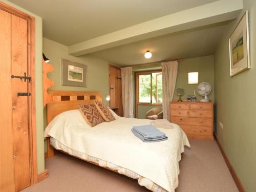 a bedroom with a bed and a dresser and a window at 2 Bed in Presteigne oc-78095 in Presteigne
