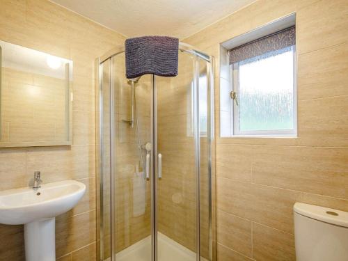 a bathroom with a glass shower and a sink at 3 Bed in Bala oc-88351 in Frongoch