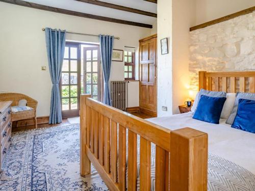 a bedroom with a large bed with blue pillows at 1 Bed in Swansea oc-77980 in Penclawdd