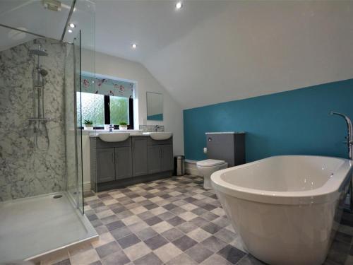 a bathroom with a tub and a sink and a toilet at 4 Bed in Llanrwst oc-66510 in Llanrwst