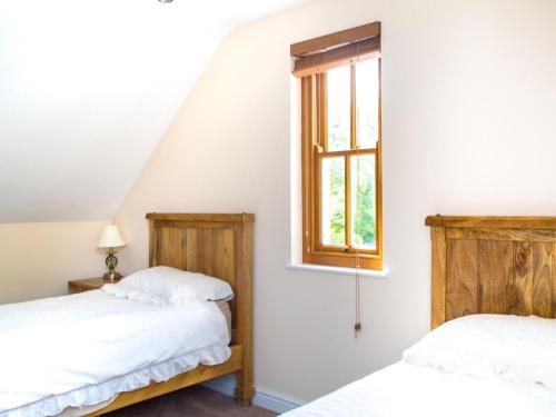 two beds in a room with a window at 2 Bed in Narberth oc-36797 in Llawhaden