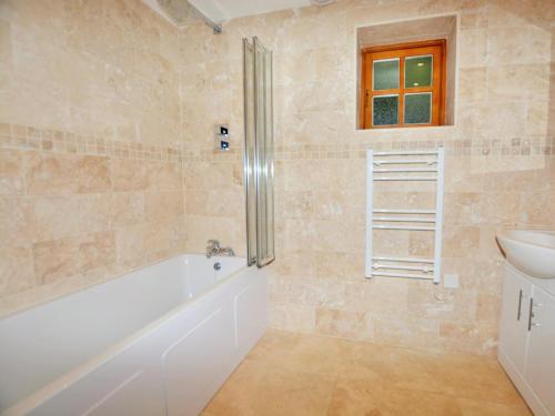 a bathroom with a bath tub and a sink at 2 Bed in Narberth oc-36797 in Llawhaden