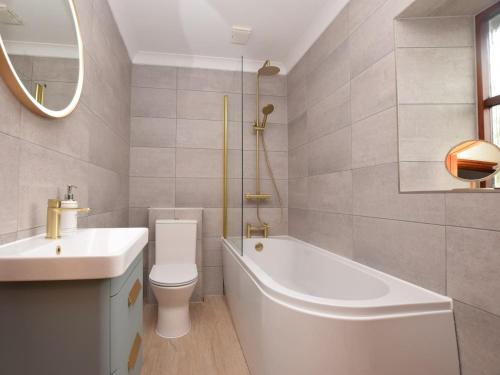 a bathroom with a tub and a toilet and a sink at 2 Bed in Clynderwen oc-82445 in Clynderwen