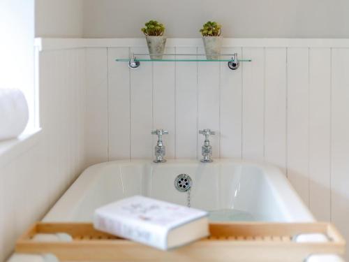 a white bath tub with two plants on a shelf at 3 Bed in Presteigne oc-78350 in Kinsham