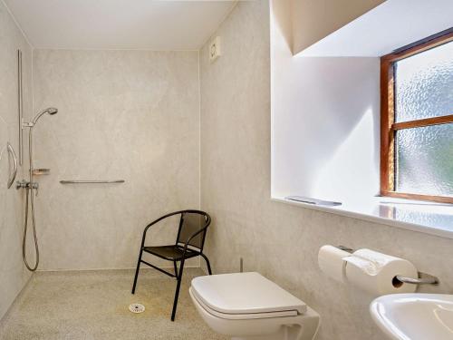a bathroom with a toilet and a chair in it at 2 Bed in Conwy oc-42573 in Llangelynin