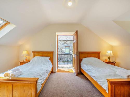 two beds in a room with a window at 2 Bed in Conwy oc-42573 in Llangelynin