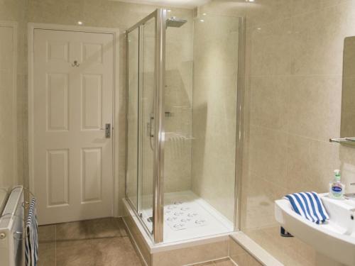 a shower with a glass door in a bathroom at 2 Bed in Tenby oc-fb284 in Tenby