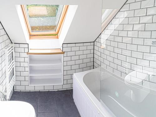 a bathroom with a white tub and a window at 3 Bed in Narberth oc-36798 in Llawhaden