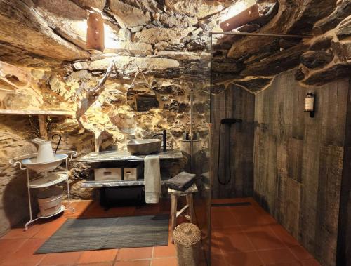 a kitchen with a stove and a stone wall at Cardenha das Formiguinhas in Monção