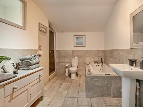 a bathroom with a sink and a toilet and a tub at 2 Bed in Swansea oc-78845 in Ilston