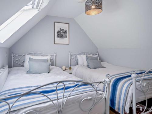two beds in a attic bedroom with white walls at 2 Bed in Swansea oc-95129 in Penclawdd